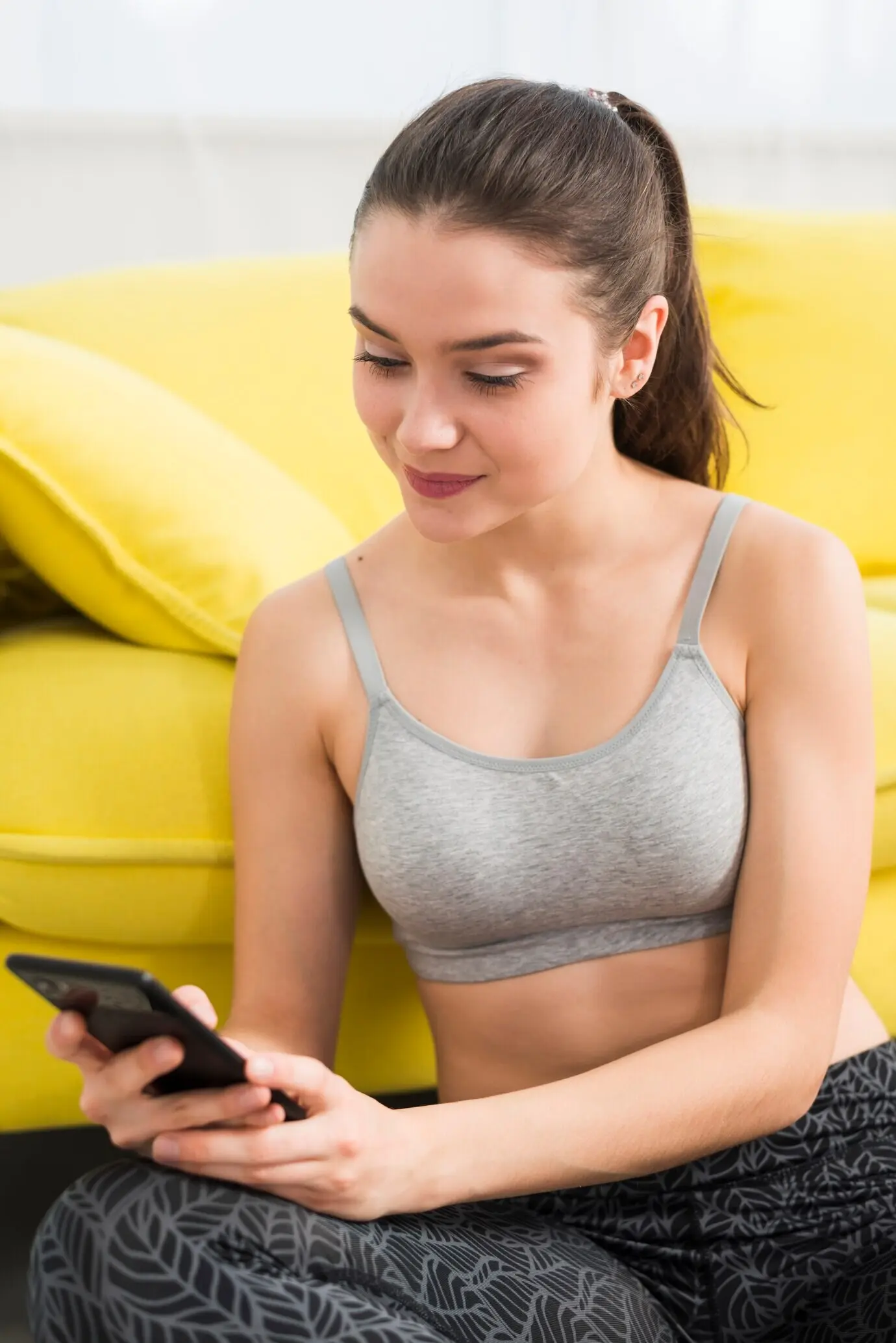 Ein Fitness-Mädchen, das ihr Handy benutzt