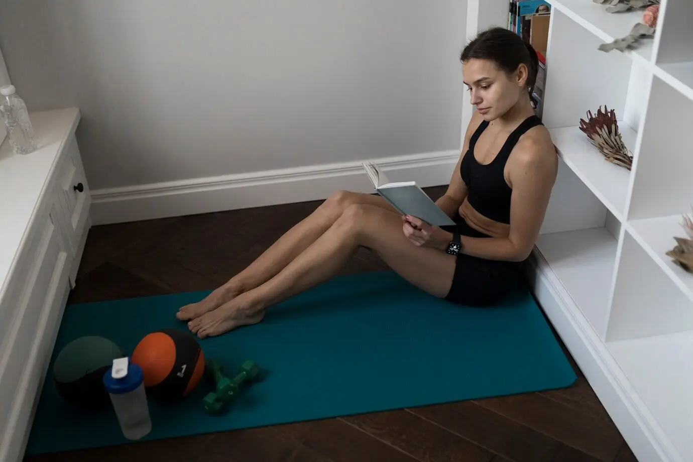 Seitenansicht einer sportlichen Frau beim Lesen eines Buches